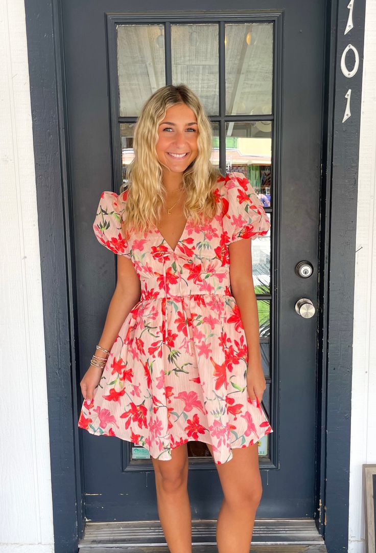 Get ready to turn heads in The Esmeralda Dress! This quirky and playful mini dress features a beautiful floral print, statement puff sleeves, and a flattering flare silhouette. The v-neck with tie closure adds a touch of whimsy, while the side pockets make it both stylish and functional. A must-have for any fashionista's wardrobe! Lilli is wearing a size Small. Height is 5’3, Bust is 32”, Waist 26”, and Hips 33”. Flirty Puff Sleeve Dress For Vacation, Feminine Floral Print V-neck Mini Dress, Flowy Mini Dress With Floral Print And Puff Sleeves, Spring Vacation V-neck Puff Sleeve Dress, Spring V-neck Puff Sleeve Dress With Floral Print, Feminine Mini Puff Sleeve Dress With Floral Print, Spring Floral Print V-neck Puff Sleeve Dress, Pink Puff Sleeve Dress With Floral Print, Pink Floral Print Flowy Puff Sleeve Dress