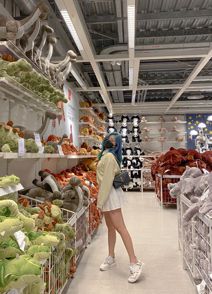 a woman standing in front of shelves filled with stuffed animals