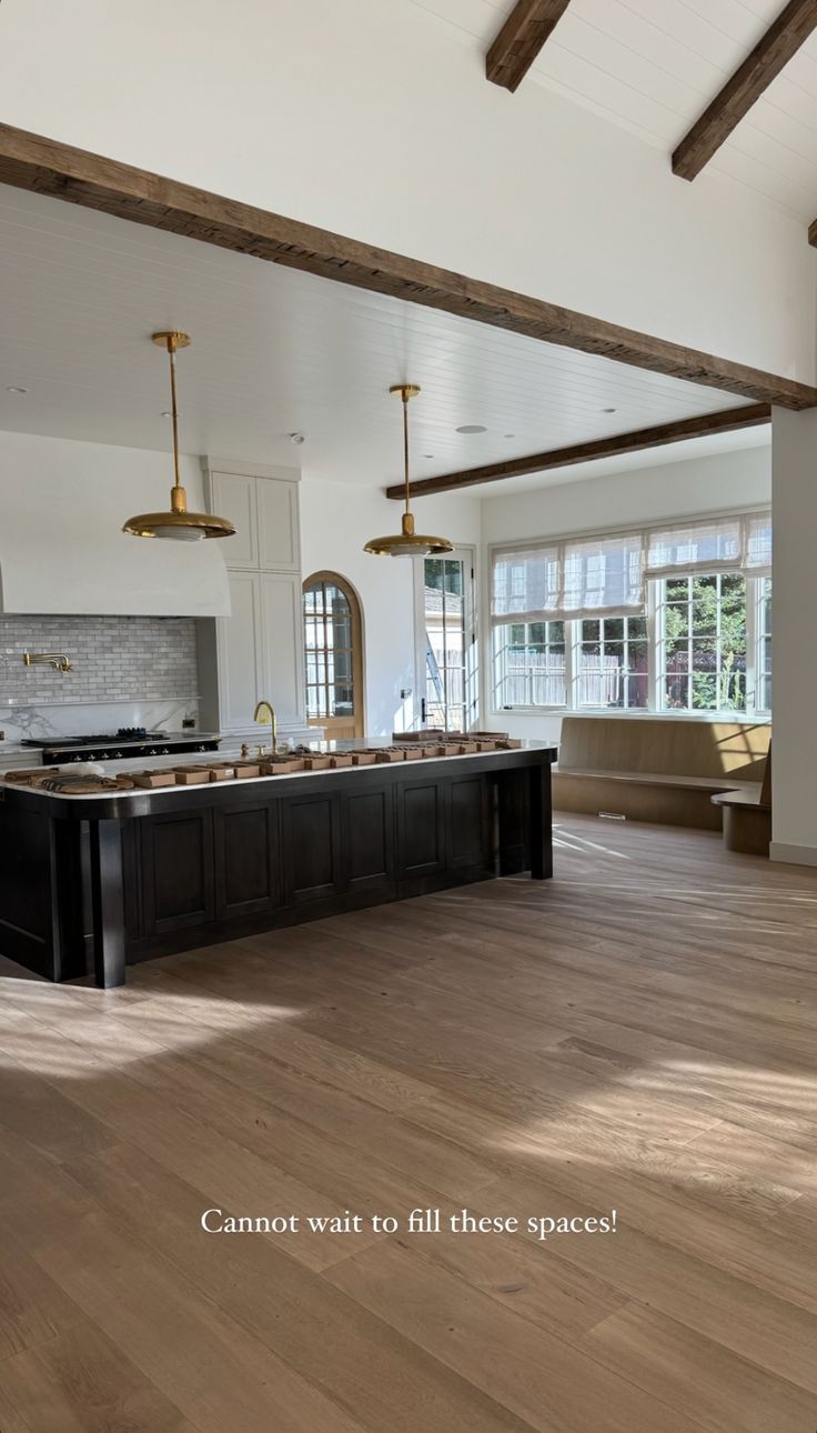 a large kitchen with wooden floors and white walls