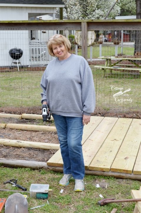 a woman is standing in the yard with tools