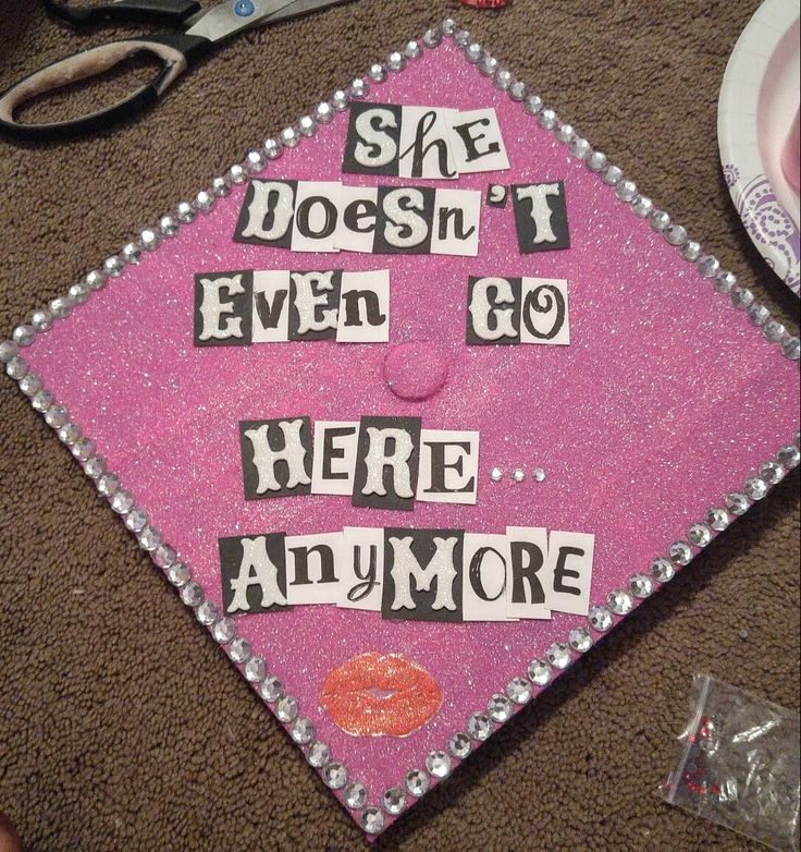 a pink graduation cap that says she doesn't even go here anymore with the words on it