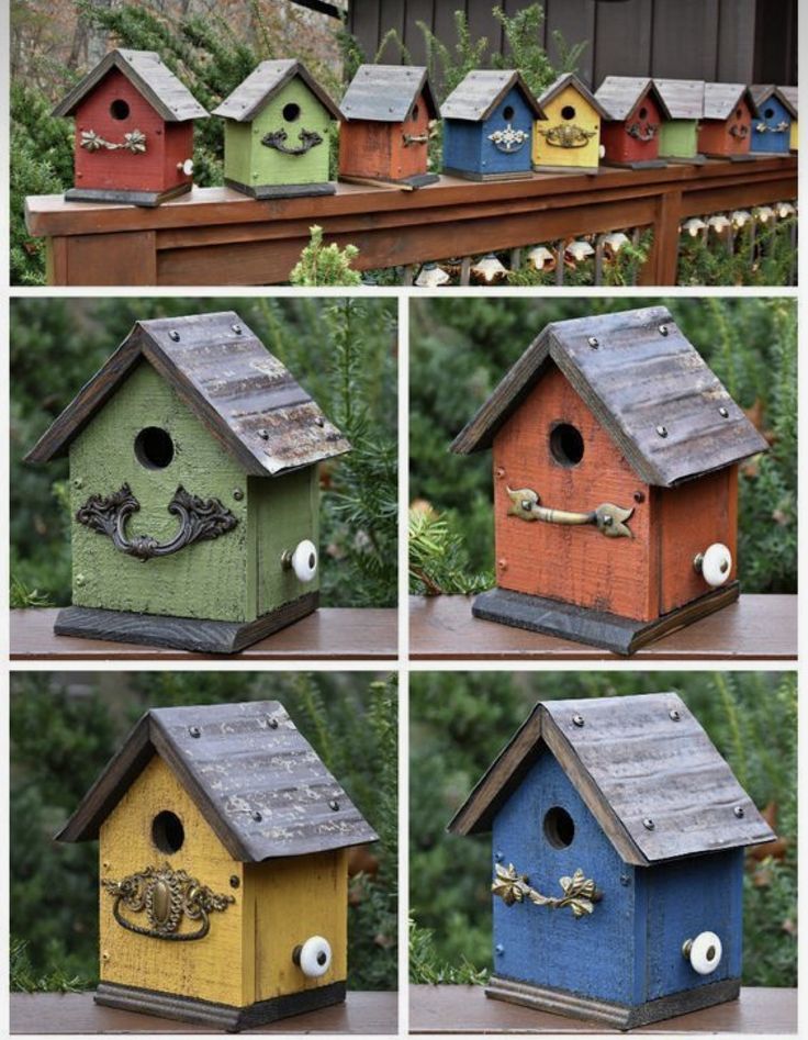 several different colored bird houses on top of a wooden fence