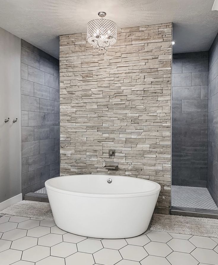 a large white bath tub sitting in a bathroom next to a walk in shower stall