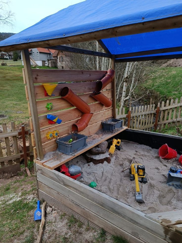 an outdoor sandbox with tools in it