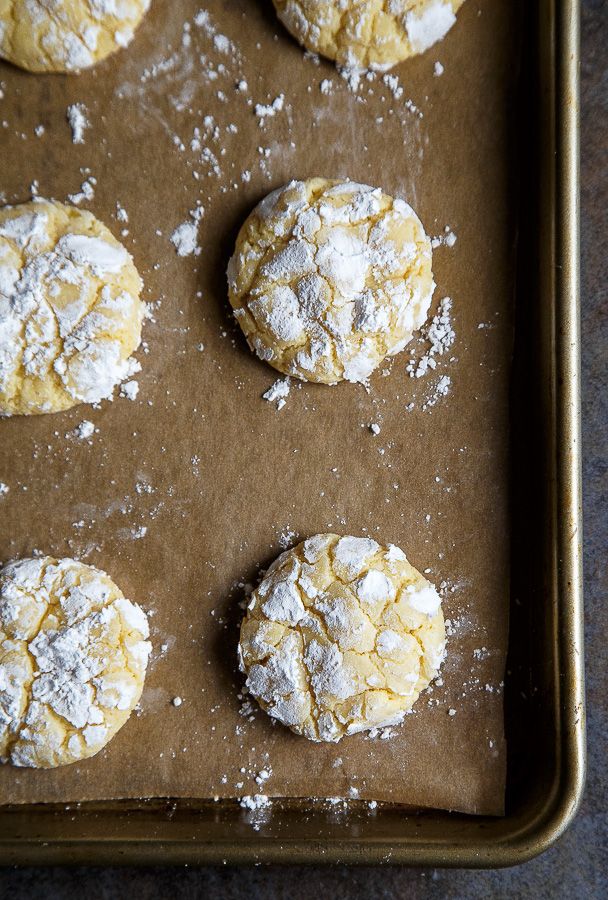 several cookies are on a cookie sheet covered in powdered sugar