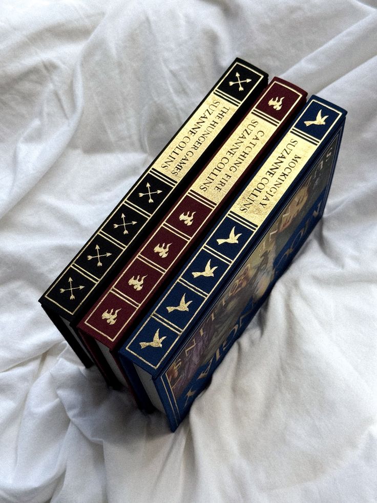 three books sitting on top of a white sheet