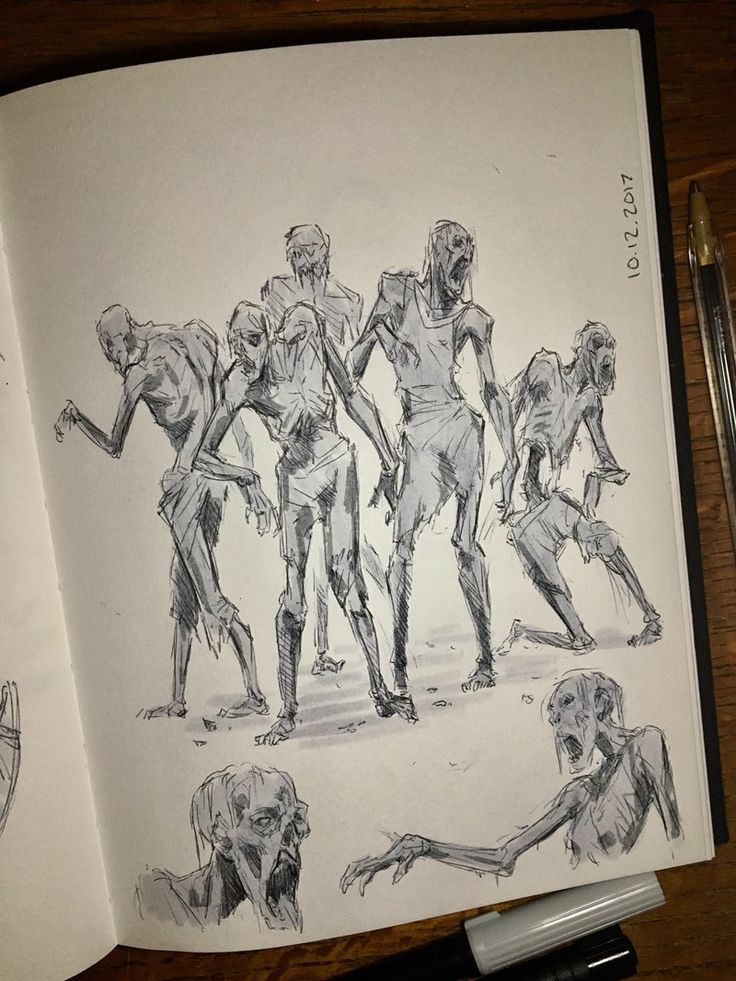 an open book with drawings of zombies on it and a pen in front of it