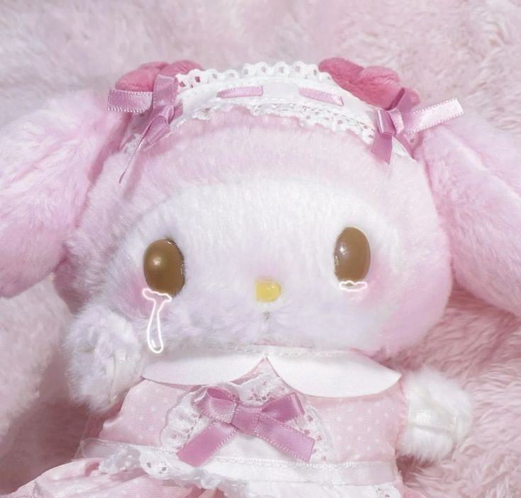 a pink stuffed animal wearing a white dress