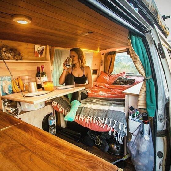 a woman sitting in the back of a camper van