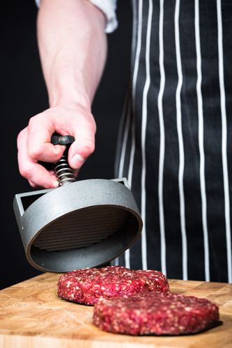 a person is using a meat slicer to cut up some food on a cutting board