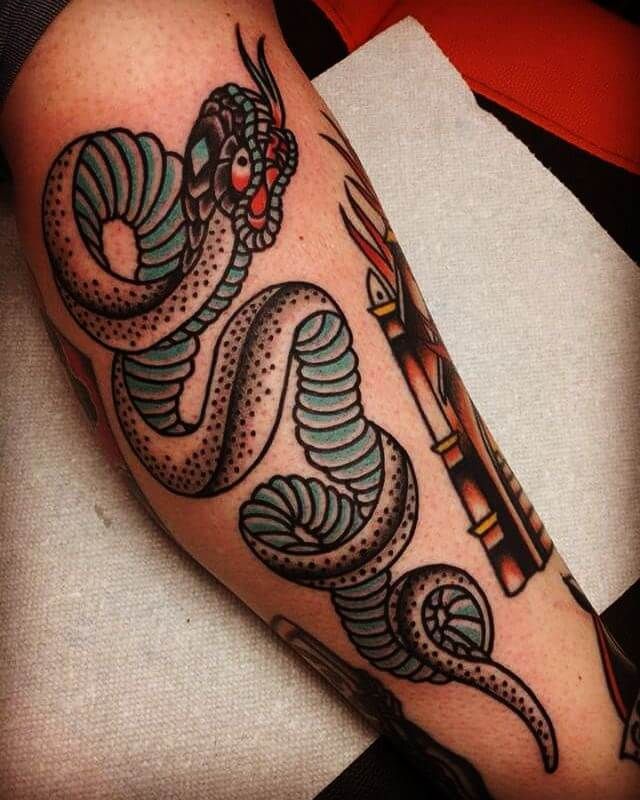 an arm with a snake and arrow tattoo design on it's left side leg