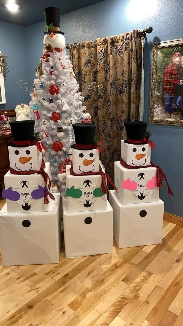 a christmas tree with snowmen on it and presents in front of it, all wrapped in white paper