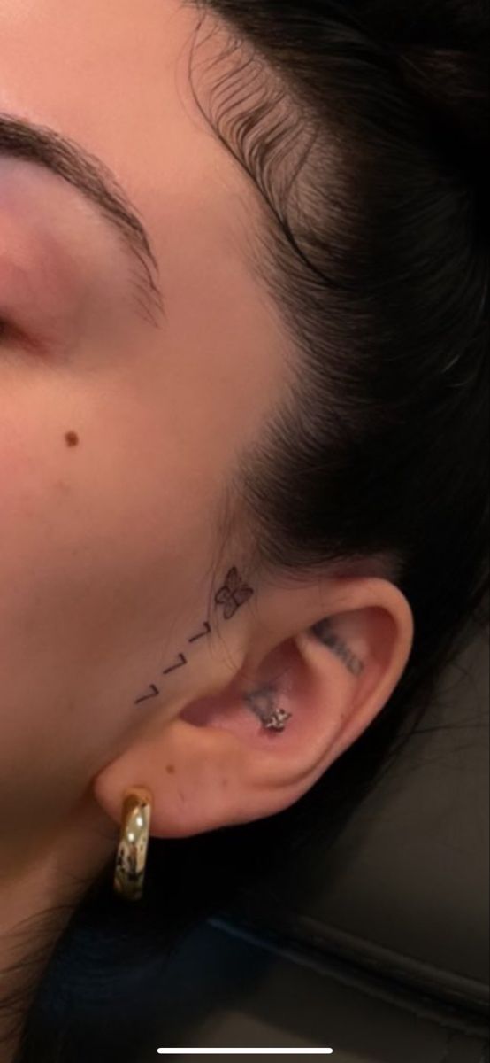 a woman with tattoos on her face and ear