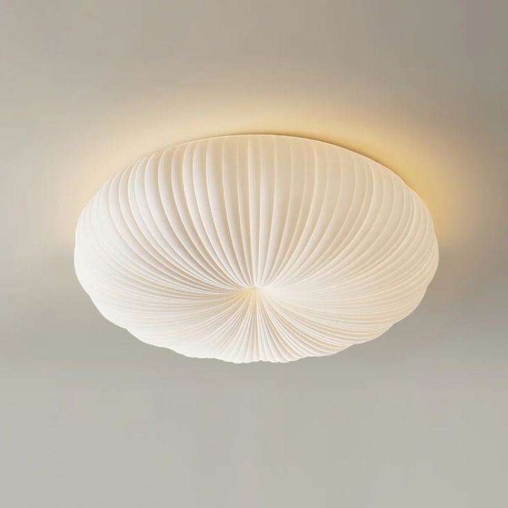 a white circular light fixture hanging from the ceiling