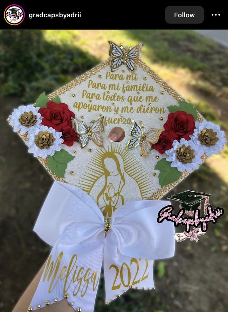 someone is holding up a graduation cap with flowers and butterflies on the front, which reads