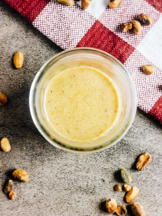 a glass jar filled with peanut butter sitting on top of a checkered table cloth