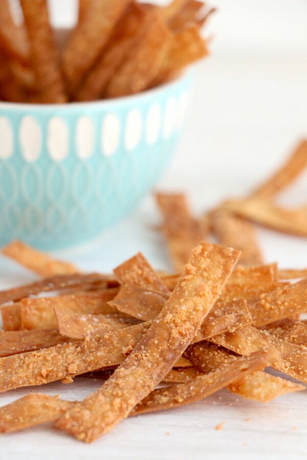 a blue bowl filled with crispy crackers on top of a white table