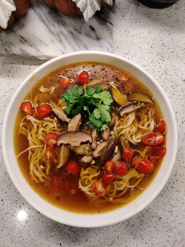 a bowl of soup with mushrooms and tomatoes