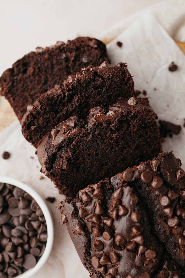 slices of chocolate cake sitting next to a bowl of chocolate chips