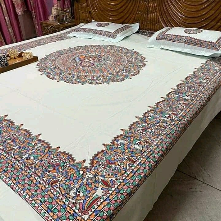 a bed with an intricately designed comforter and pillows