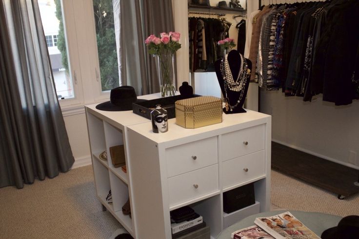 a white dresser sitting inside of a bedroom next to a window