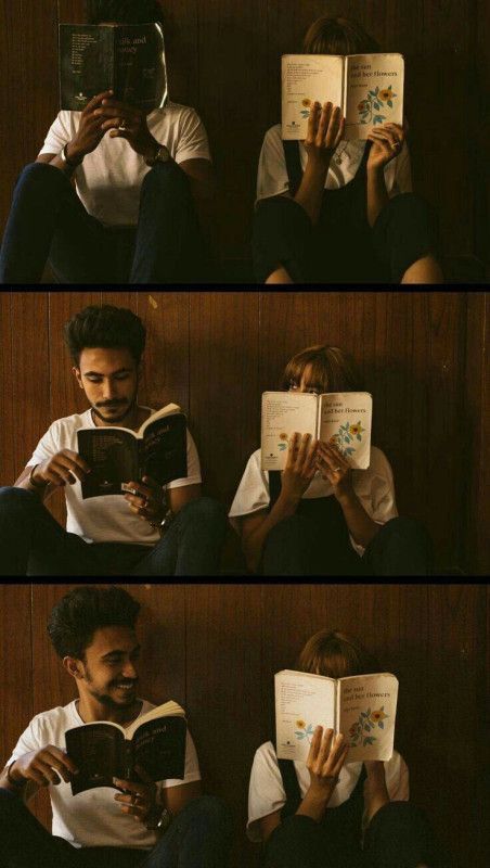 two people sitting on the floor reading books and one is holding an open book in his hands