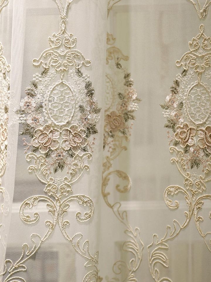 the sheer curtains are decorated with flowers and leaves on them, along with lace trimmings