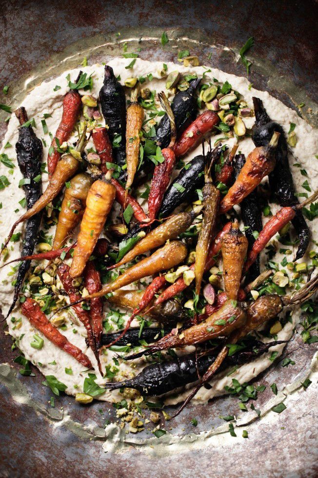 an assortment of carrots and other vegetables on top of a tortilla shell