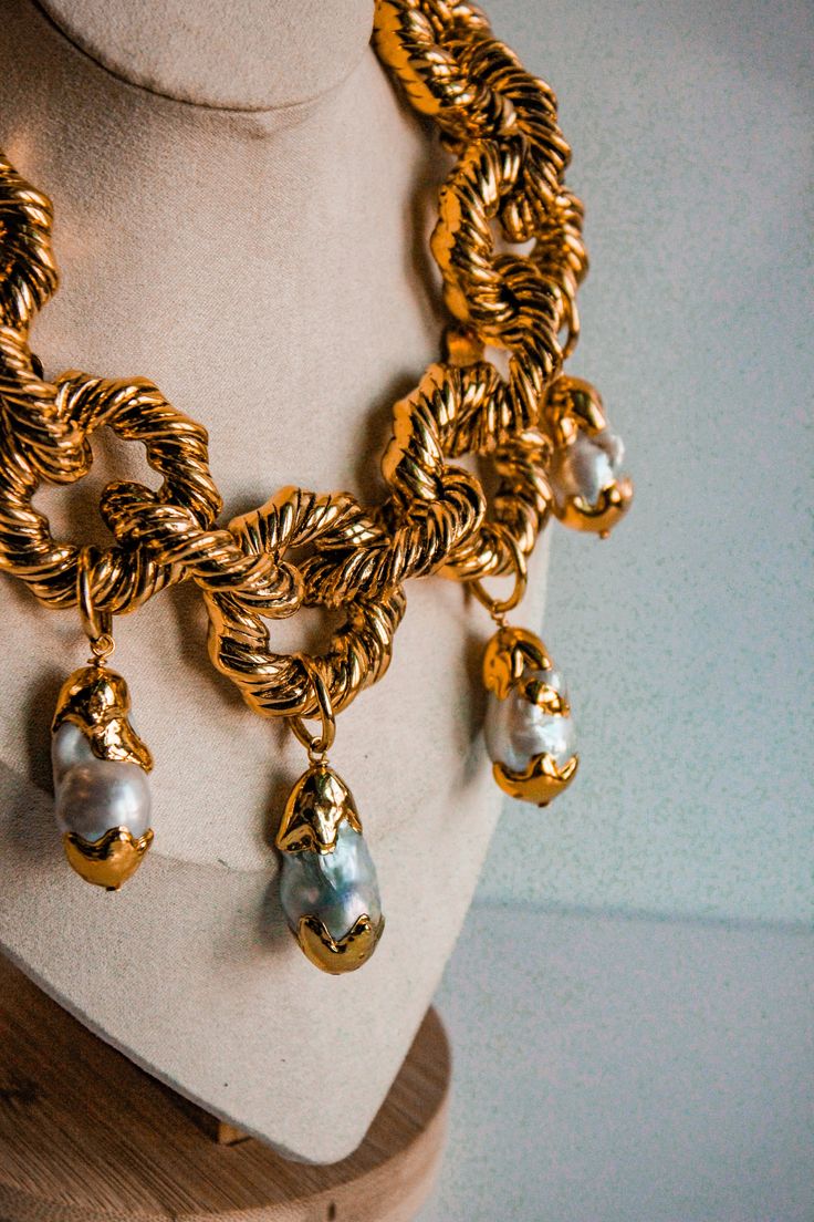 A stunning statement piece unfolds with our Chunky Rope Chain Necklace, adorned with five exquisite Baroque Pearl Pendants enclosed in intricately crafted gold-plated twirls. Each pearl, showcasing its unique natural beauty, adds an element of grace and allure to this exceptional necklace. The chunky rope style chain not only enhances durability but also elevates the necklace to a bold fashion statement. Perfect for both everyday elegance and special occasions, this necklace is a must-have addit Opulent Gold-plated Gold Jewelry, Opulent Gold-plated Jewelry, Luxury Pearl Chain Necklace, Handmade Luxury Gold Chain Necklace, Luxury Handmade Gold Chain Necklace, Luxury Baroque Pearl Jewelry For Party, Elegant Gold Baroque Jewelry, Opulent Gold Pendant Necklace, Handmade Baroque Gold Jewelry