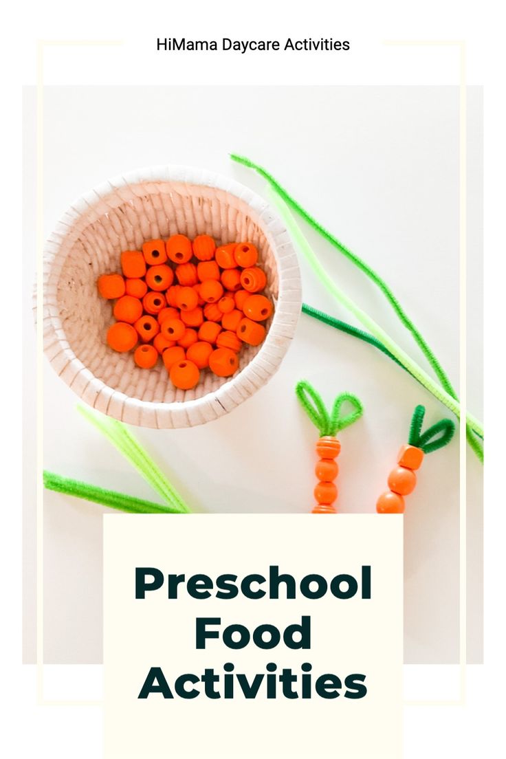 a bowl filled with carrots sitting on top of a white table next to green stems