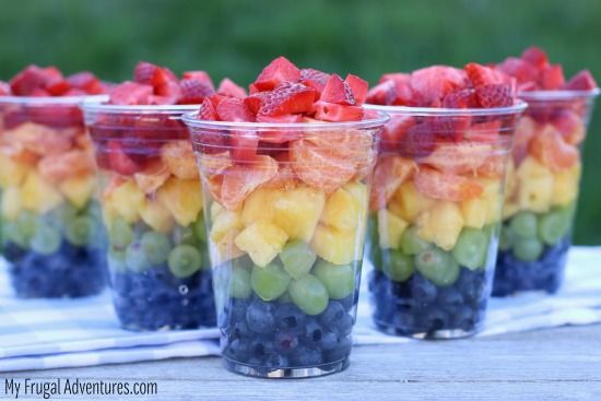 three plastic cups filled with fruit on top of a table