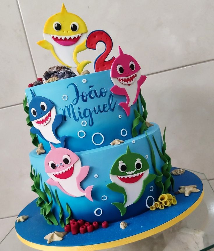 there is a cake decorated with sharks on the bottom and under it's name