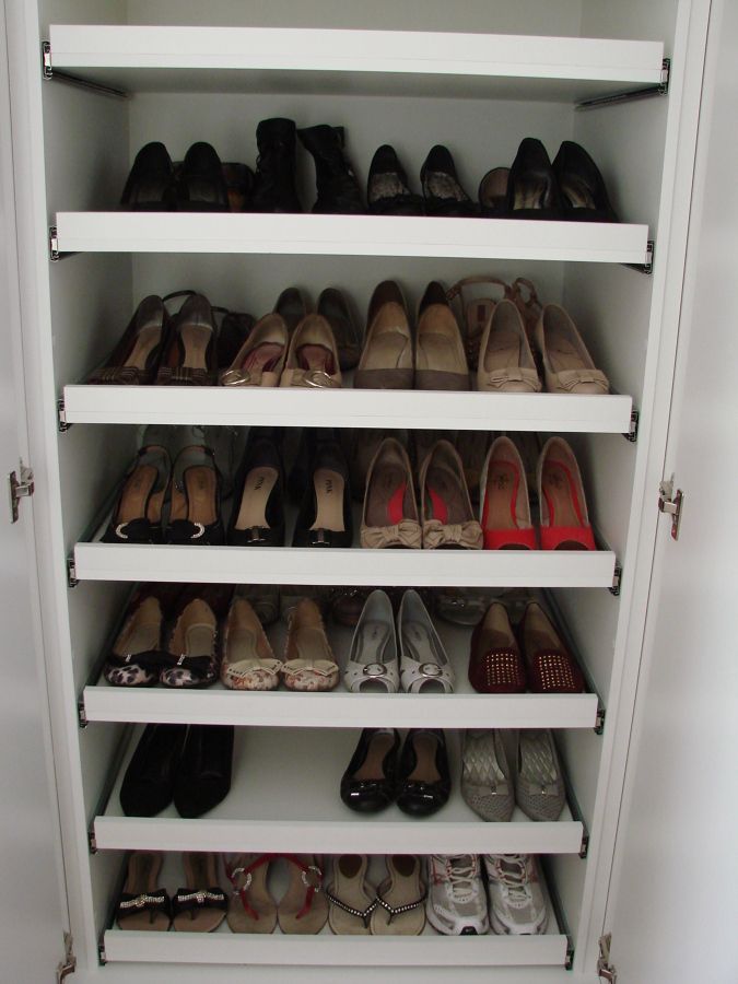 a white closet filled with lots of shoes