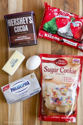 the ingredients to make christmas cookies laid out on top of a wooden table, including milk, sugar, and candy