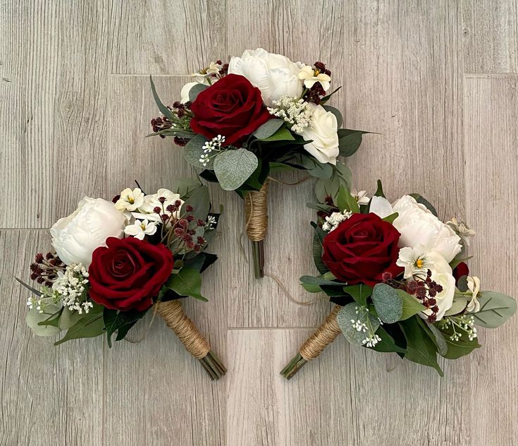 three bouquets of flowers arranged on the floor