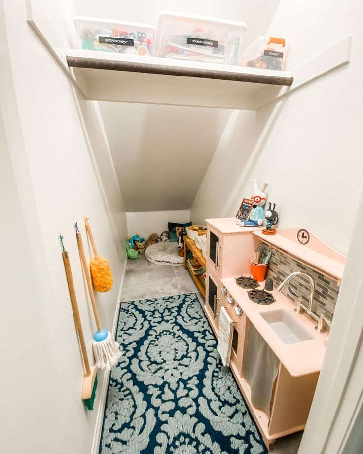 an attic kitchen with blue and white rugs