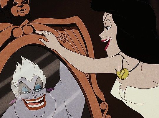 an animated character is looking at herself in the mirror while another character looks on from behind