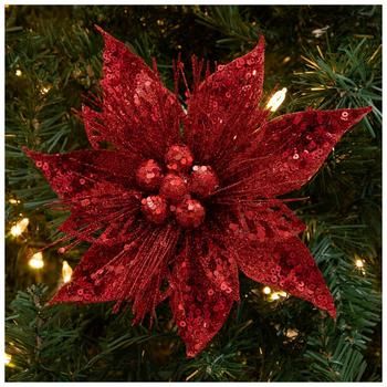 a red poinsettia ornament hanging from a christmas tree