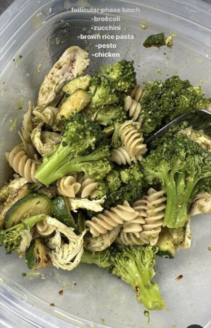 a plastic container filled with pasta and broccoli