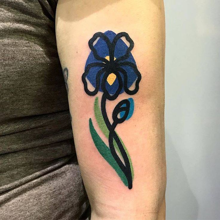 a woman's arm with a blue flower tattoo on the left side of her arm