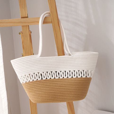 a white basket hanging from a wooden ladder