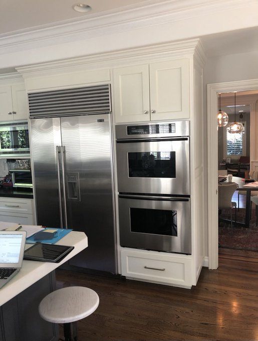 a modern kitchen with stainless steel appliances and white cabinets