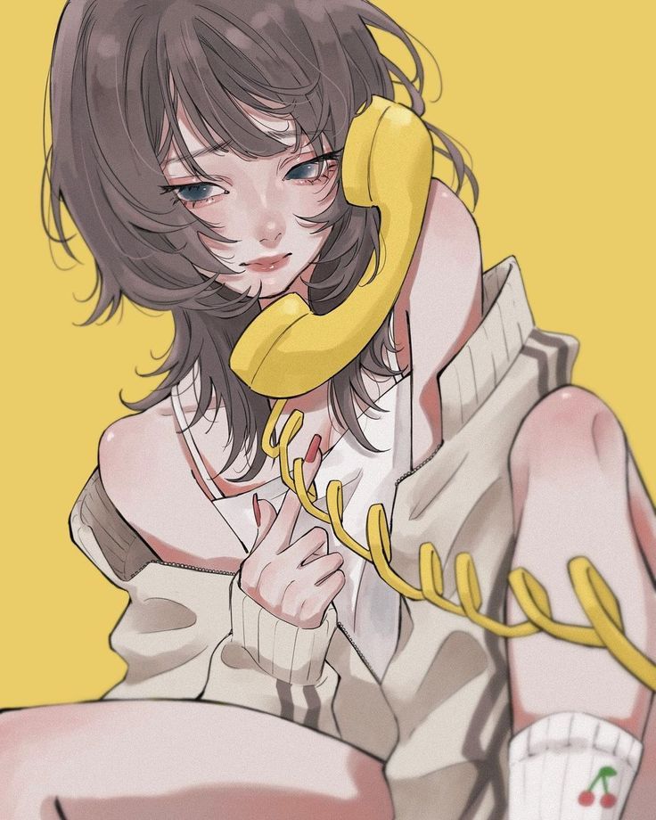 a woman sitting on the ground while talking on a yellow phone with her hand up to her ear