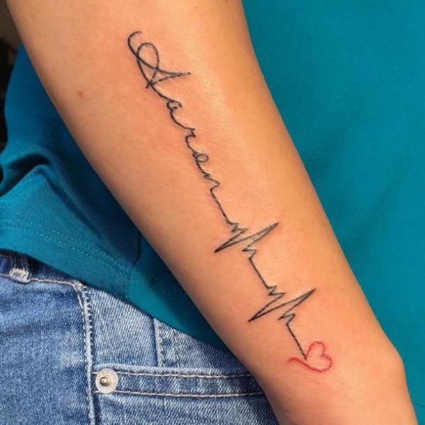 a woman's arm with a heartbeat tattoo on it