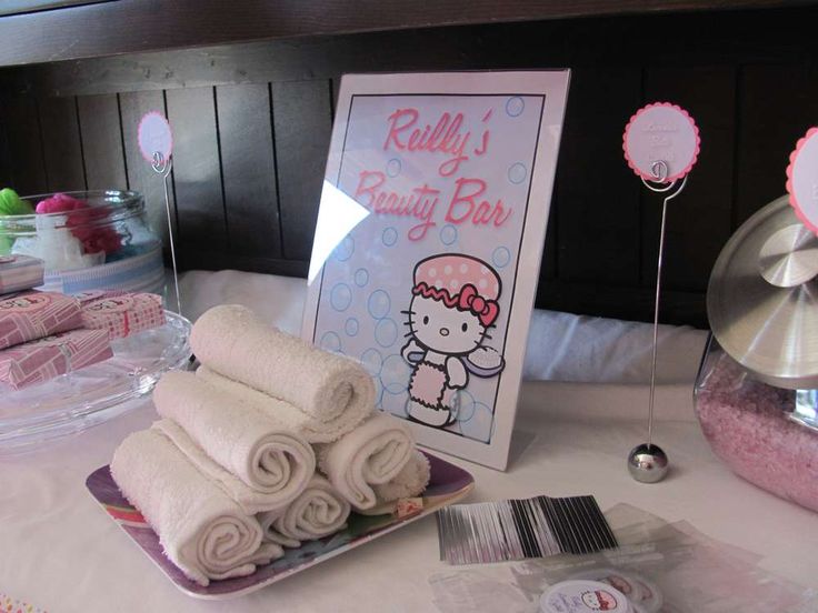 a hello kitty themed baby shower is set up on a table with pink and white decorations