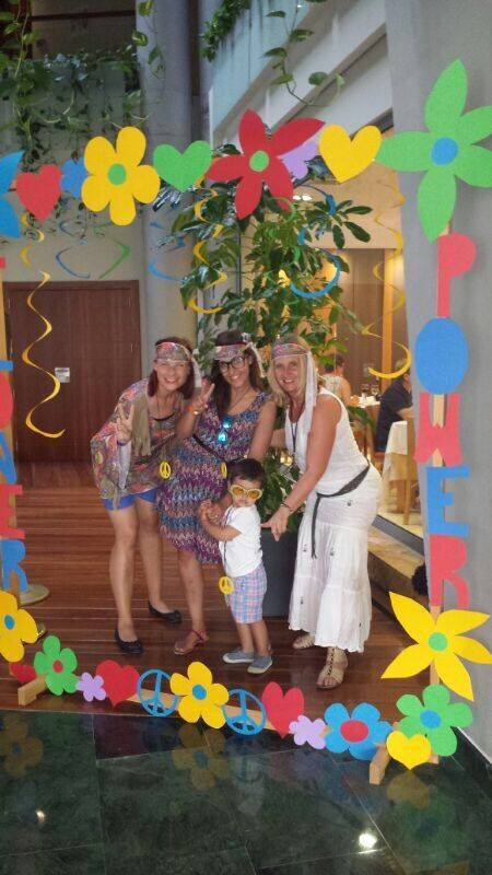 three women and a baby are posing for a photo in front of a paper flower frame