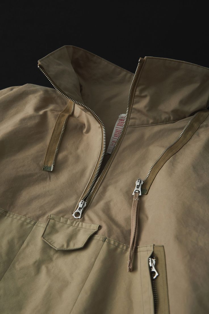 This cold-weather parka is a cross between a 1940s British smock and the design and specifications of an American mountain parka, developed in a unique interpretation. The fabric was commissioned to the first factory in Japan to be certified as an official producer of military uniform fabrics. Egyptian Giza cotton is used and woven to the highest possible density to provide water repellency. Functional Khaki Parka For Outdoor Work, Beige Parka With Pockets For Outdoor, Brown Utility Parka For Outdoor, Brown Outerwear With Kangaroo Pocket For Outdoor, Outdoor Techwear Outerwear With Kangaroo Pocket, Khaki Utility Parka For Hiking, Khaki Utility Windbreaker With Double-lined Hood, Utility Khaki Windbreaker With Double-lined Hood, Utility Style Khaki Windbreaker With Double-lined Hood