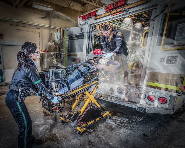 two women in front of an ambulance being loaded onto a stretcher