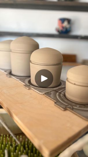 three clay pots sitting on top of a wooden table