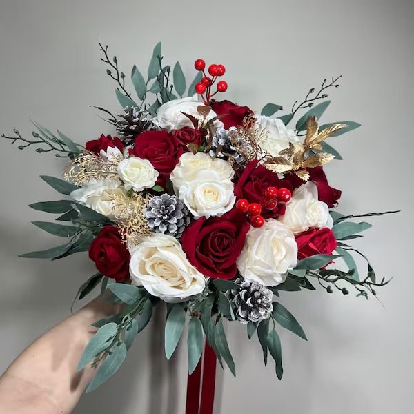 a person holding a red and white bouquet